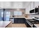 Updated kitchen with stainless steel appliances, dark cabinets, and a door leading to the backyard at 262 Calvino Ave, Las Vegas, NV 89183