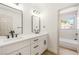 Bathroom featuring double sinks, modern black hardware, a large mirror and a view into the shower at 2632 Cathedral Ln, Las Vegas, NV 89108