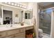 Clean, brightly-lit bathroom featuring dual sinks, framed mirrors, and a glass-enclosed shower at 2636 Highvale Dr, Las Vegas, NV 89134