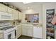 Functional kitchen with white appliances, a view to the dining room, and plenty of storage at 2636 Highvale Dr, Las Vegas, NV 89134