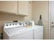 Functional laundry area with side-by-side washer and dryer and overhead cabinet storage at 2636 Highvale Dr, Las Vegas, NV 89134