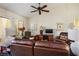 Inviting living room featuring comfortable leather seating, a ceiling fan, and natural light at 2636 Highvale Dr, Las Vegas, NV 89134