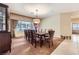 Formal dining room features a long table with seating for ten, complemented by window views and stylish decor at 2783 Cherrydale Falls Dr, Henderson, NV 89052