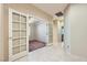 Inviting hallway featuring tiled flooring, an open doorway to a carpeted room, and double doors to a bedroom at 2783 Cherrydale Falls Dr, Henderson, NV 89052