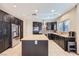 Contemporary kitchen with a large island, stainless steel refrigerator, and dark cabinets for a sleek design at 2783 Cherrydale Falls Dr, Henderson, NV 89052