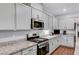 Modern kitchen featuring granite countertops, stainless steel appliances, and sleek white cabinets at 3026 English Palmer Rd, North Las Vegas, NV 89086