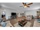 Open-concept living room with wood flooring, ceiling fan, and seamless flow to the kitchen and dining area at 3026 English Palmer Rd, North Las Vegas, NV 89086