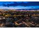 Aerial view of the residential neighborhood showcasing houses, tree-lined streets, and the dazzling Las Vegas skyline at night at 3057 Downing Pl, Las Vegas, NV 89121