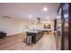 Spacious, open-concept kitchen featuring a large island with barstools, stainless appliances, and wood flooring at 3057 Downing Pl, Las Vegas, NV 89121