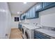 Well-organized laundry room with blue cabinets, gray countertops, and modern washer and dryer units at 3057 Downing Pl, Las Vegas, NV 89121