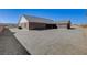 Rear view of a brick house, with a gray gravel yard, tile roof, and lots of open space at 3196 Mateuse St, Logandale, NV 89021