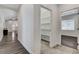 Hallway leading to a carpeted room, showcasing a walk-in pantry with shelving and overhead lighting at 3196 Mateuse St, Logandale, NV 89021