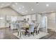 Open-concept kitchen with island, dining area, gray wood floors, and white cabinets at 3196 Mateuse St, Logandale, NV 89021