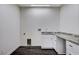 Clean laundry room with white cabinets, granite countertop, and modern appliances at 3196 Mateuse St, Logandale, NV 89021