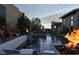 Contemporary pool area with fire features, artistic wall decor, and manicured greenery at 333 Highview Ridge Ave, Las Vegas, NV 89138