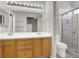 A modern bathroom features double sinks, wood cabinets, and a sleek glass shower at 3505 Tuscany Village Dr, Las Vegas, NV 89129