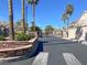 Gated community entrance lined with lush landscaping and mature palm trees on a sunny day at 3505 Tuscany Village Dr, Las Vegas, NV 89129