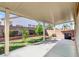 Covered patio with green grass yard featuring small trees and block wall fence for outdoor enjoyment at 3505 Tuscany Village Dr, Las Vegas, NV 89129