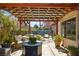 Shaded backyard patio overlooks pool area with rock waterfall feature and manicured yard at 3620 Bahama Bay Ct, Las Vegas, NV 89147