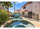 Tropical backyard pool with rock features, lush landscaping, and desert views at 3620 Bahama Bay Ct, Las Vegas, NV 89147