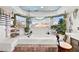 A luxurious soaking tub is surrounded by plants and natural light with decorative accents at 3620 Bahama Bay Ct, Las Vegas, NV 89147