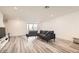 Modern living room with wood-look floors, gray sectional sofa, and natural light at 3772 Brilliant Sunset St, Las Vegas, NV 89129