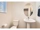 Charming powder room featuring a pedestal sink, oval mirror, and modern fixtures at 3772 Brilliant Sunset St, Las Vegas, NV 89129