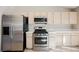 Well-lit kitchen featuring stainless steel appliances, white cabinets, and tile countertops at 4016 Fairport Dr, North Las Vegas, NV 89032