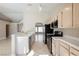 Open kitchen with tile countertops, stainless appliances, and view of the open-concept floorplan at 4016 Fairport Dr, North Las Vegas, NV 89032