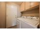 Laundry room featuring a white washer and dryer, overhead cabinets, and door to outside at 4016 Fairport Dr, North Las Vegas, NV 89032