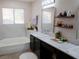 Bathroom with double sinks, modern fixtures, and a bathtub with marble-style tiling at 425 Donner Pass Dr, Henderson, NV 89014