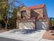 Two-story stucco home with a red tile roof and a three-car garage at 425 Donner Pass Dr, Henderson, NV 89014