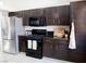 Kitchen featuring dark wood cabinets, stainless steel appliances, and granite countertops at 425 Donner Pass Dr, Henderson, NV 89014