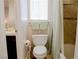 Cozy bathroom featuring a toilet under a window and a shower with a patterned curtain at 425 Donner Pass Dr, Henderson, NV 89014