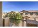 View of the two-story home featuring neutral colors, a tiled roof, and dark shutters, seen from a balcony at 4542 Townwall St, Las Vegas, NV 89115