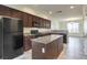 Modern kitchen with an island, granite counters, dark cabinetry, and stainless steel appliances at 4542 Townwall St, Las Vegas, NV 89115