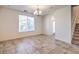 The living room is brightly lit and features tile flooring, a modern chandelier, and a staircase at 4542 Townwall St, Las Vegas, NV 89115