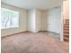 An open living room featuring carpeted floors and a large window with blinds at 4542 Townwall St, Las Vegas, NV 89115