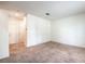 A large, carpeted living room with a white door and trim at 4542 Townwall St, Las Vegas, NV 89115