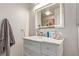 Bathroom with marble top vanity, decorative hardware, a large, lighted mirror, and a gray towel at 4786 Valleyside Ave, Las Vegas, NV 89115