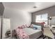 Bedroom with gray floors, gray accent wall, gray comforter and a desk area at 4786 Valleyside Ave, Las Vegas, NV 89115