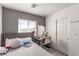 Cozy bedroom featuring a grey accent wall, natural light, and ample closet space at 4786 Valleyside Ave, Las Vegas, NV 89115