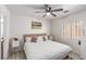 Nicely staged bedroom with white linens, gray floors, and a ceiling fan at 4786 Valleyside Ave, Las Vegas, NV 89115