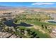 Panoramic aerial view of a golf course community with a beautiful lake, set against a stunning mountain backdrop at 4790 Toscana Pl, Pahrump, NV 89061