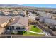 View of a landscaped backyard with artificial turf and covered patio in a residential neighborhood at 4790 Toscana Pl, Pahrump, NV 89061