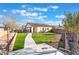 View of a backyard featuring artificial turf, desert landscaping, and a covered patio with a tile roof at 4790 Toscana Pl, Pahrump, NV 89061