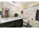 Well-lit bathroom featuring a spacious vanity with double sinks, a toilet, and a shower with a stylish curtain at 4790 Toscana Pl, Pahrump, NV 89061