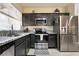 Modern kitchen featuring dark cabinets, stainless steel appliances, and granite countertops at 4790 Toscana Pl, Pahrump, NV 89061