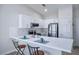 Bright kitchen with white cabinets, stainless steel appliances, a breakfast bar, and marble-look backsplash at 4980 Black Bear Rd # 104, Las Vegas, NV 89149