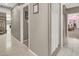 Long hallway with multiple doorways, beige walls, and tile flooring at 5200 Valley Glen St, Las Vegas, NV 89119